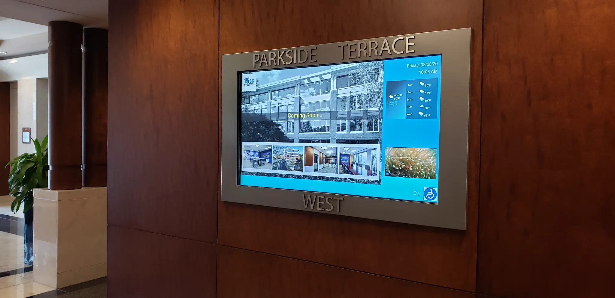 Parkside Terrace West lobby with interactive digital directory touch screen mounted on wood-paneled wall
