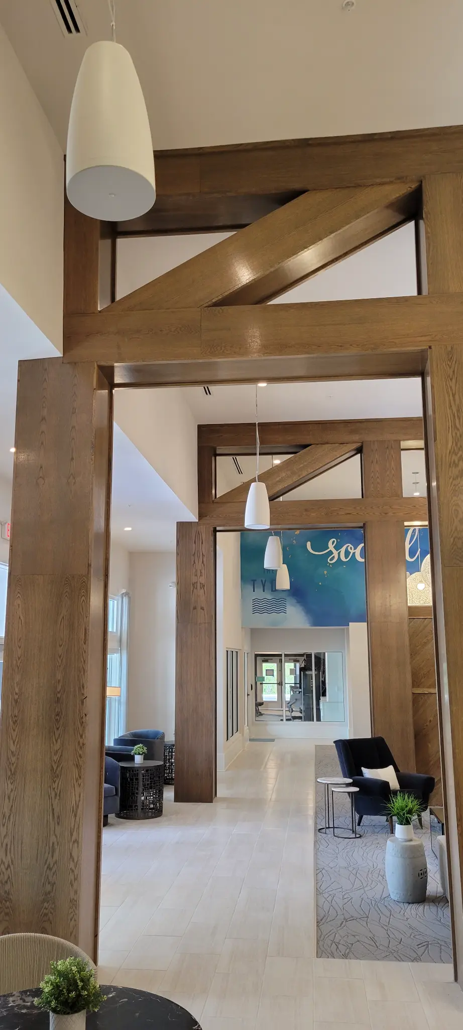 The TYDE social lounge with pendant audio speakers and wood accent walls