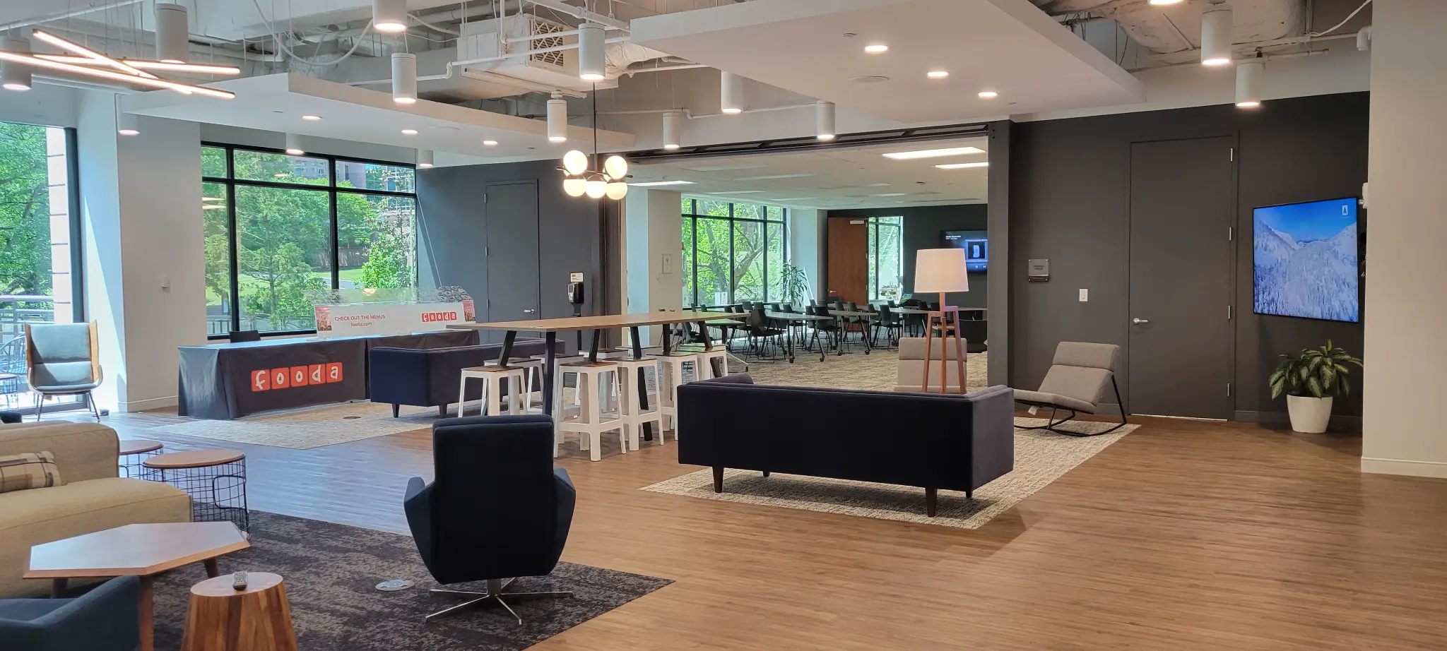 Bridge Commercial Lenox lounge with wall-mounted display and adjoining training room