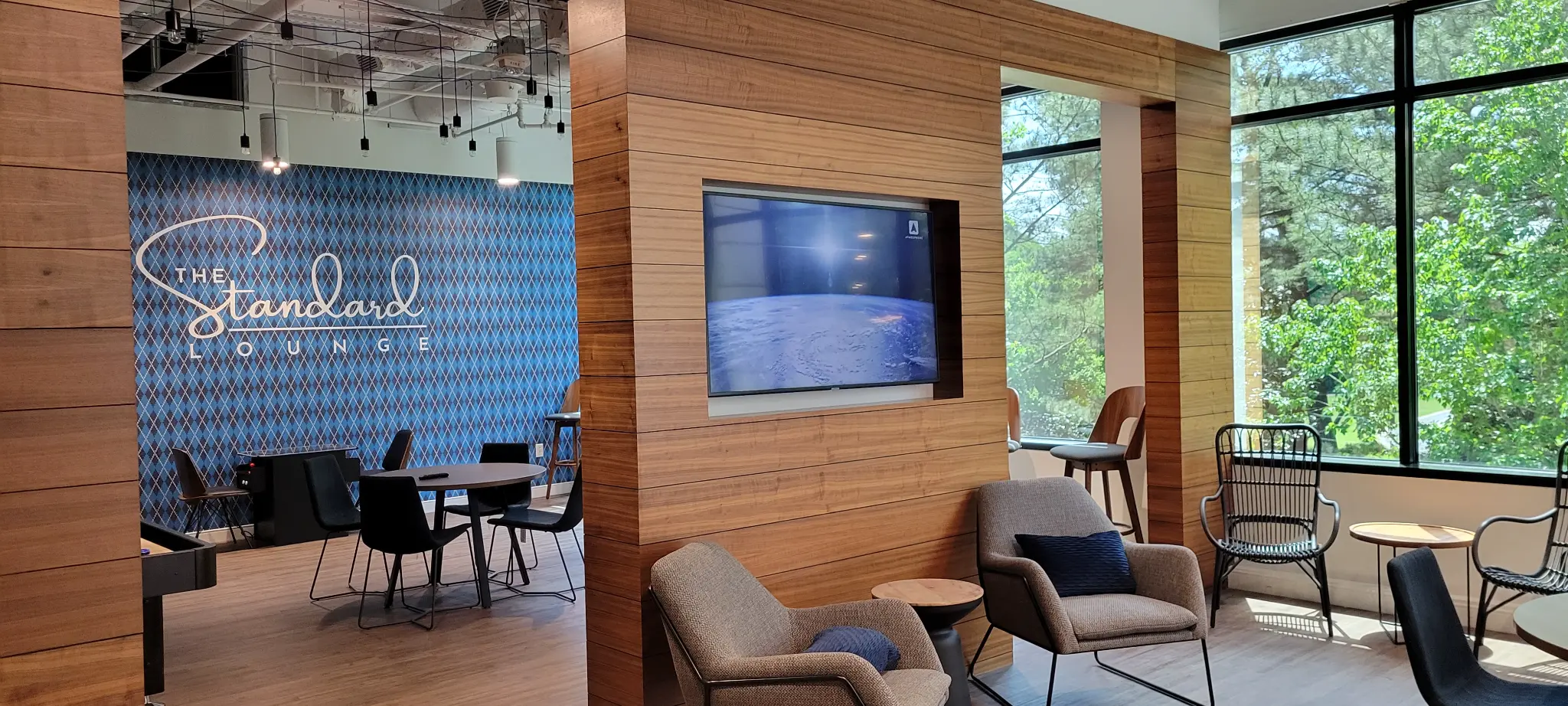 Display integrated into a wood-paneled lounge wall at Bridge Commercial Lenox