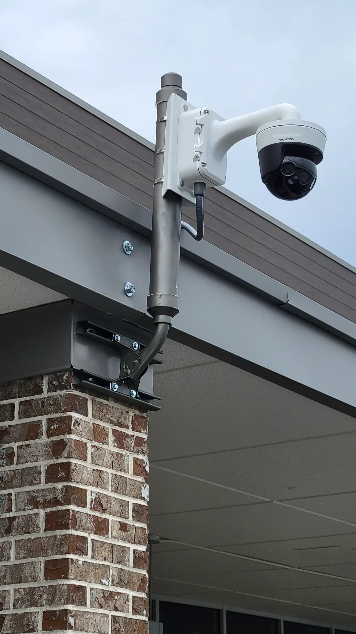 Hikvision dome security camera mounted on exterior wall at Chamblee Plaza