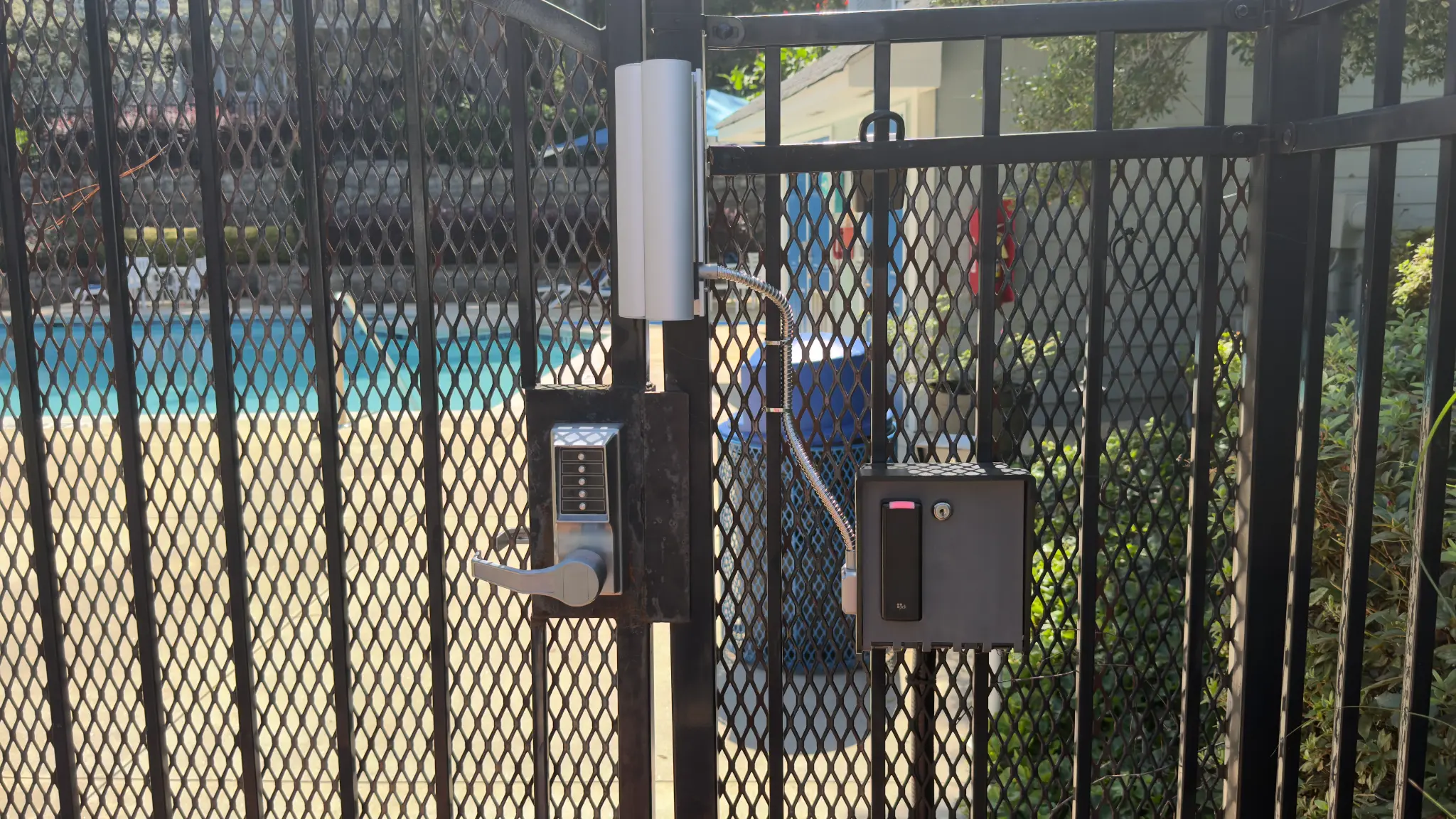 Pool gate locking hardware and PDK access reader at The Willows HOA