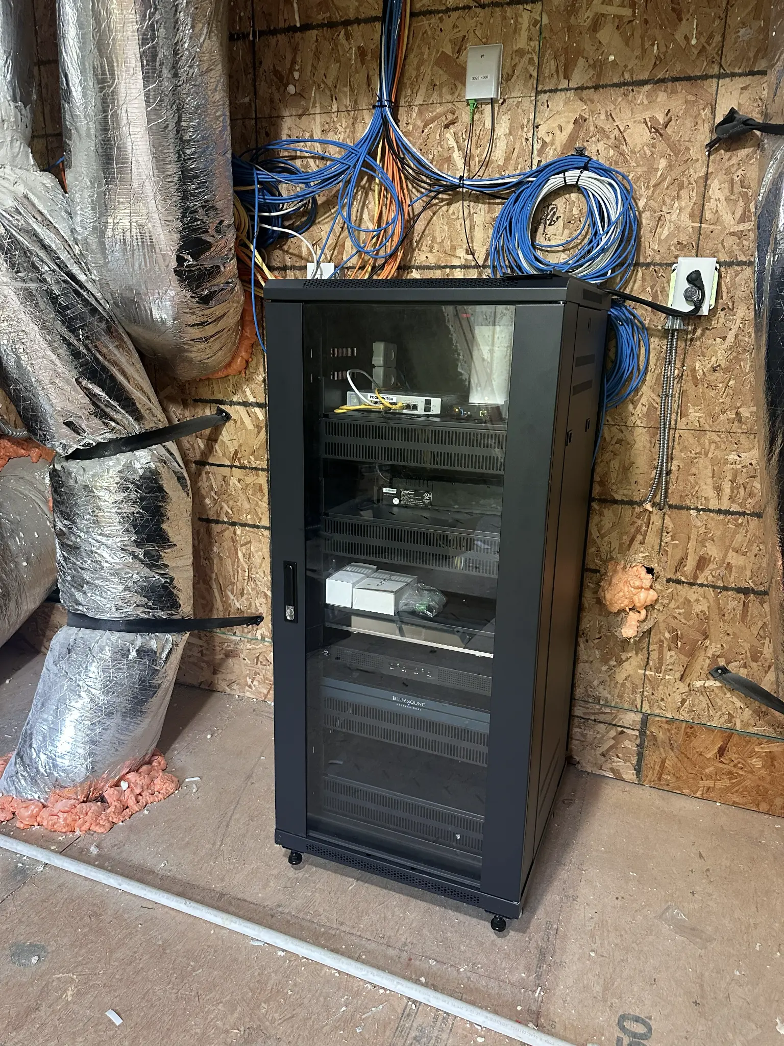 BlueSound streamer, Labgruppen amplifier, and network equipment in rack at TUXFORD HOA clubhouse