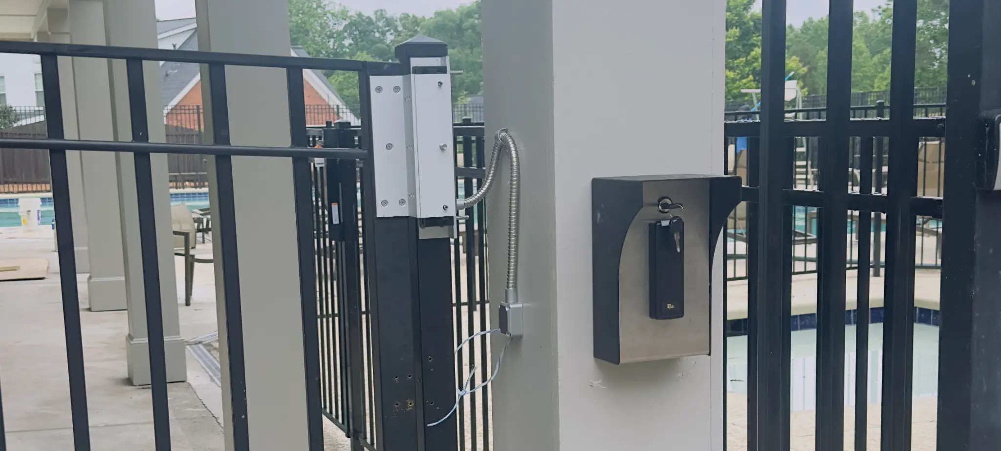 TUXFORD HOA pedestrian gate with PDK access control reader and pool area in the background