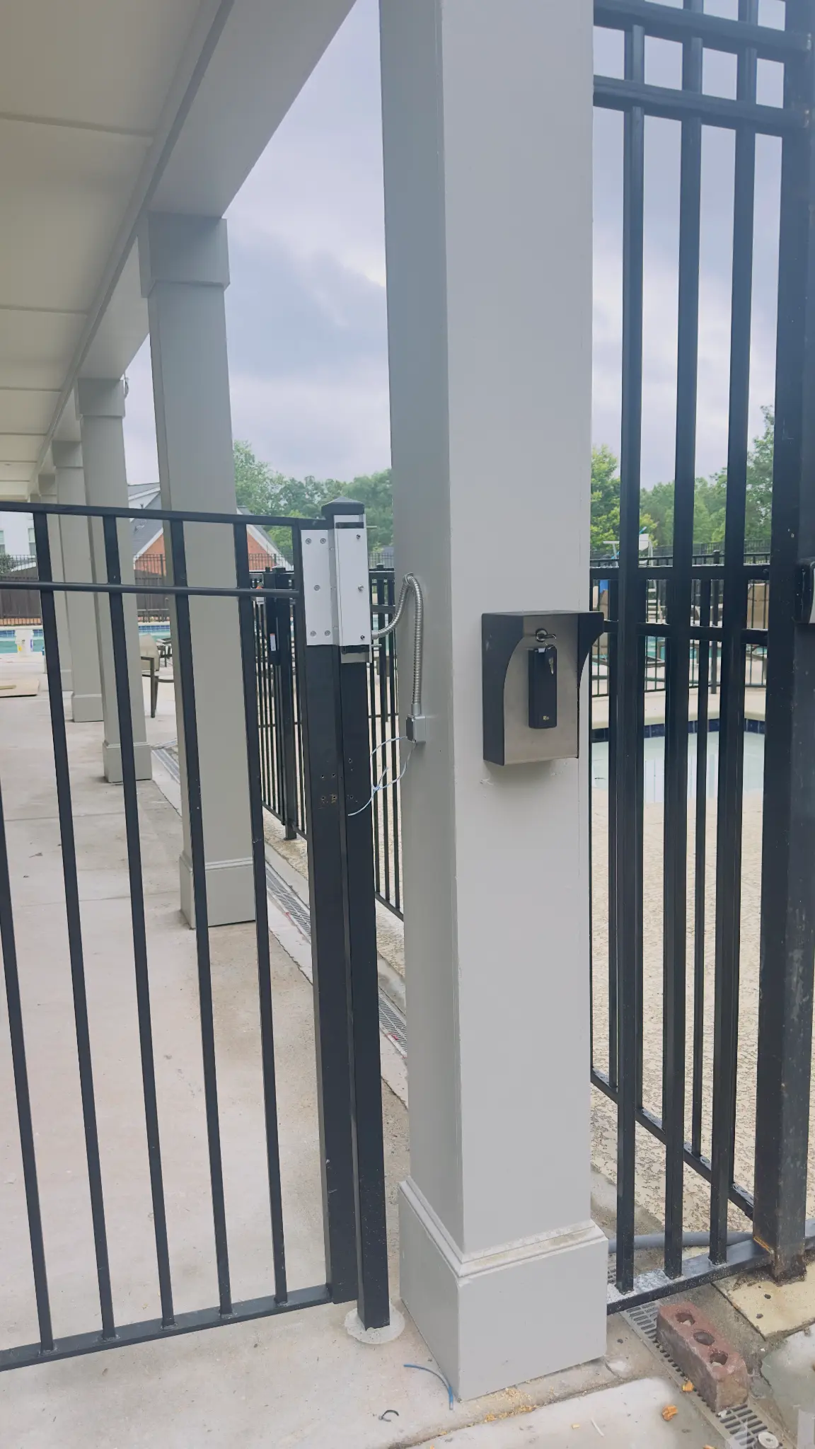 TUXFORD HOA pedestrian gate with PDK access control reader and pool area in the background